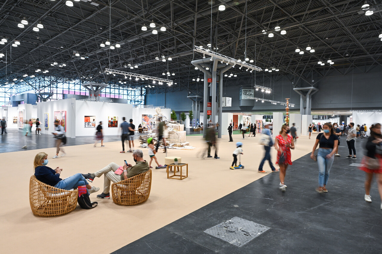 Overview of The Armory Show hall 3B at the Javits Center with visitors seating, talking and walking throughout the fair.