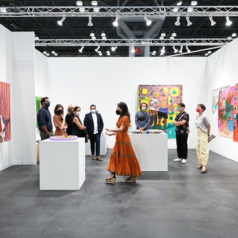 A woman leading a guided tour at the contemporary art fair in New York, The Armory Show, showing a sculpture by a contemporary artist.